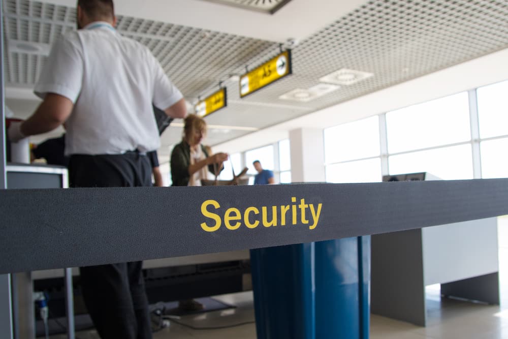 Airport security officers behind a security tape in an airport